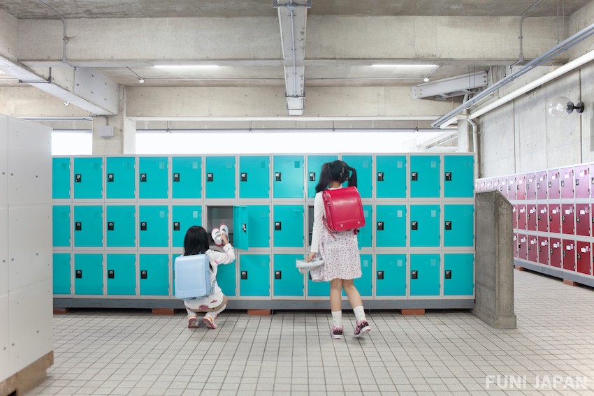 Lockers de zapatos en una escuela de japón. Hay estudiantes guardando sus zapatos.